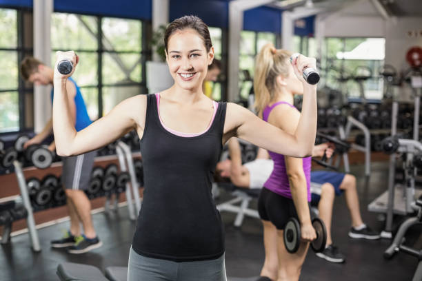 istock Smiling woman working out with dumbbells 700633852