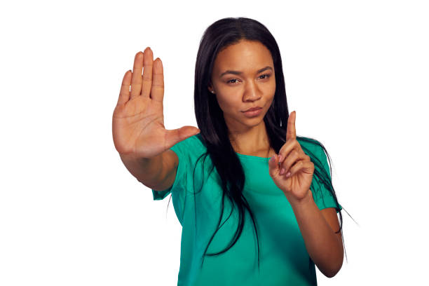 Young woman looking at camera and showing a stop sign