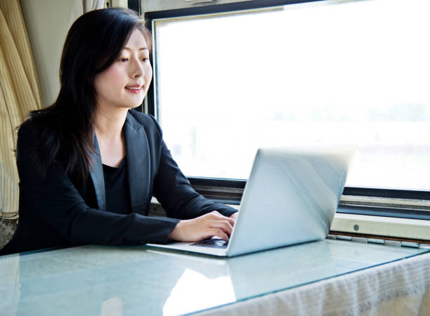istock Young businesswoman using laptop on the train 700644858