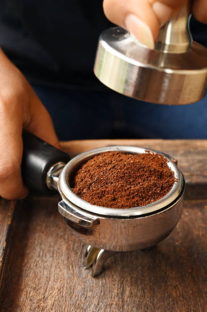 istock Freshly ground coffee beans in a metal filter on hand 700646698