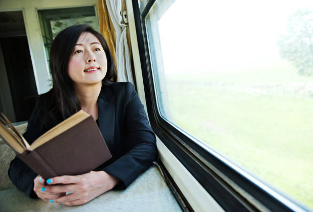 istock Young businesswoman reading book on a train 700646738