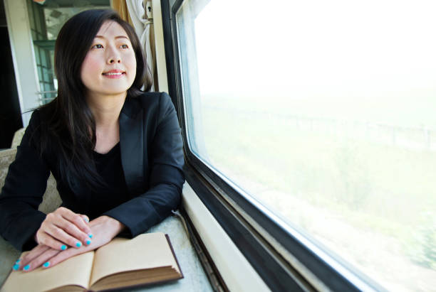 istock Young businesswoman reading book on a train 700646756