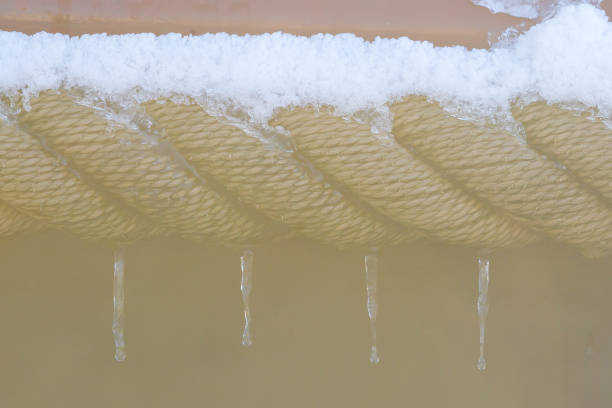 istock Nautical rope curving coil covered with snow and ice 700657788