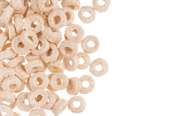 Decorative border of beige rings corn flakes isolated with copy space. Cereals background.