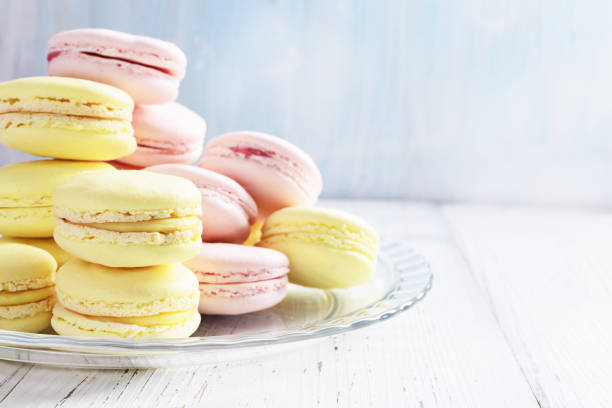 istock Yellow and pink macaroons on white wooden background. 700661632