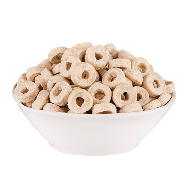 istock Beige rings corn flakes in white bowl isolated on white background. Cereals. 700663976