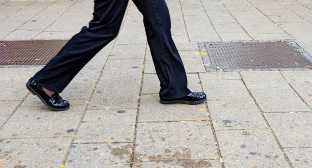 istock striding feet with black patent shoes 700665484