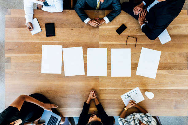 istock Multi-ethnic business people in meeting with blank pages on table 700666364