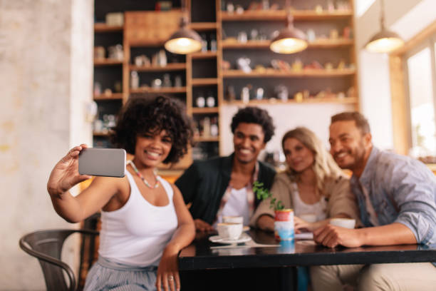 istock Multiracial friends taking selfie on smart phone at cafe 700669074