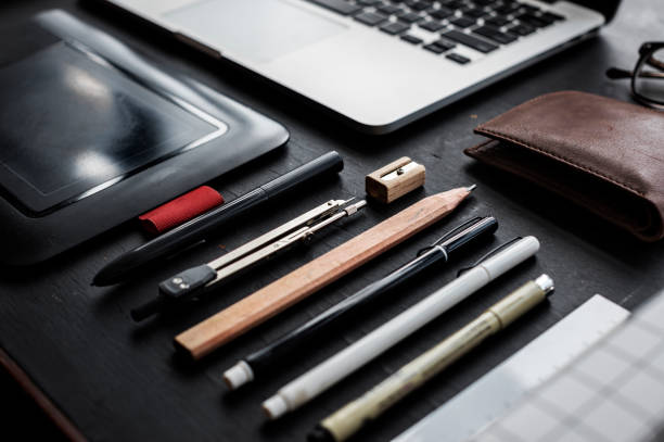 istock Closeup of various pens stationery on black table 700669476