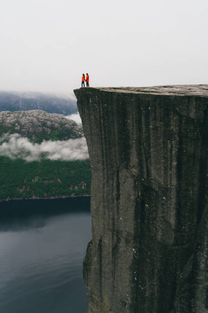 istock Couple standing  on the Preikestolen in Norway 700672416