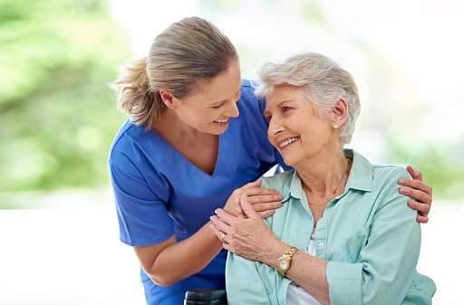 Shot of a female nurse caring for a senior patient in a retirement home