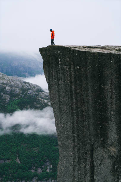 istock Man standing  on the Preikestolen in Norway 700678052