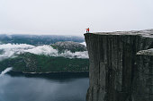 istock Couple standing  on the Preikestolen in Norway 700678060