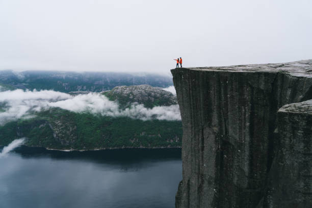 Couple standing  on the Preikestolen in Norway Young Caucasian couple standing  on the Preikestolen in Norway lysefjorden stock pictures, royalty-free photos & images