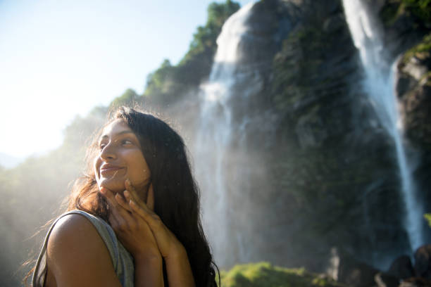 lächelnde frau genießen wasserfälle. - waterfall water nature zen like stock-fotos und bilder