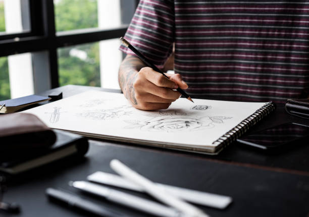 istock Closeup of tattooed hand with drawing artwork 700678574