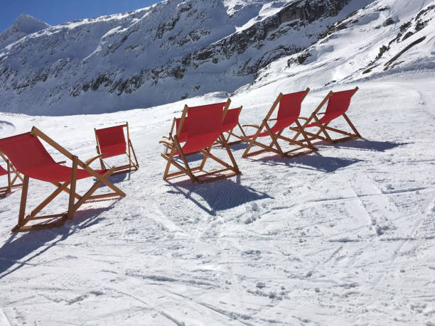 istock Winter sunbathing, deck chairs in the snow 700685976