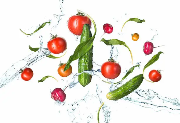 Photo of The fresh tomatos, cucumbers, radish in spray of water