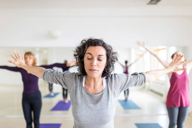 istock Mature woman stretching in gym class 700718478
