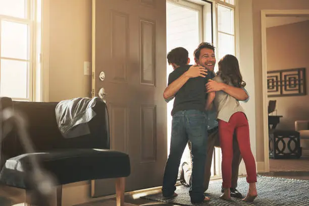 Shot of a father arriving home to a loving welcome from his son and daughter