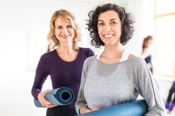 donne del fitness che si rilassano dopo la lezione di yoga - friendship women exercising gym foto e immagini stock