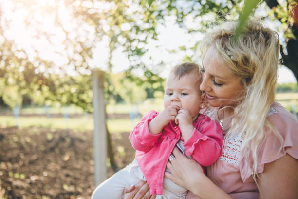 istock Mother with baby Picking Cherry In Garden 700726416