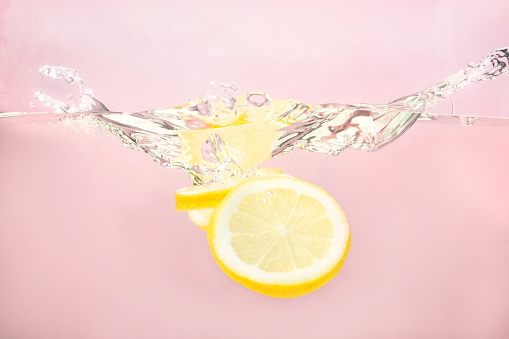 Sliced lemon with yellow background in the water