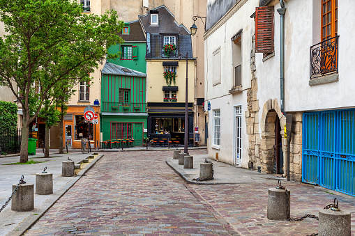 View of narrow cobblestone street and typical parisian architecture in Paris, France.