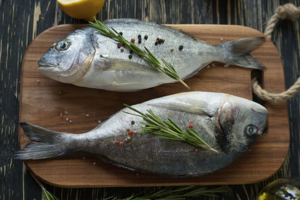 istock Raw fish cooking and ingredients. Dorado, lemon, herbs and spices. 700749926
