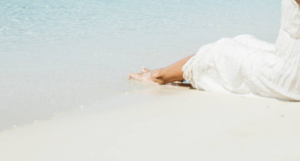 istock woman legs on the sand 700750686