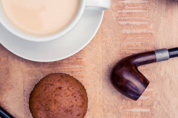 istock Coffee with muffin and smoking pipe 700769380