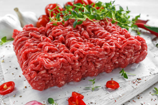 新鮮な牛肉ミンチ肉に塩、コショウ、唐辛子、新鮮なタイムのホワイト ボードに。 - meat grinder ground beef meat ストックフォトと画像
