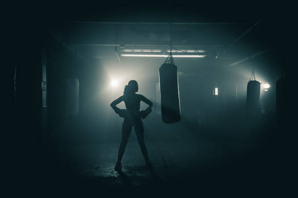 Portrait of an athlete Young woman  boxer with dramatic lighting and a grunge image technique fighting stance stock pictures, royalty-free photos & images