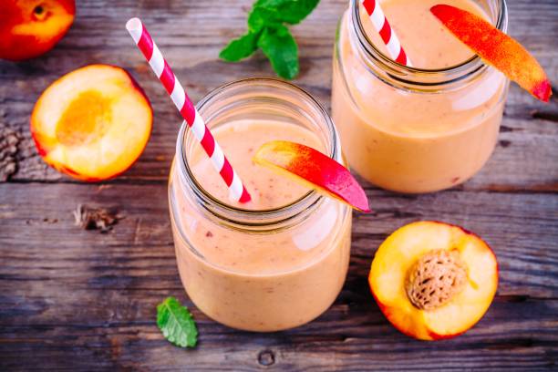 istock Nectarine smoothies in a mason jar with mint on wooden background 700776976