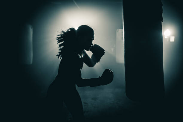Getting fit with boxing Young woman  boxer with dramatic lighting combat sport photos stock pictures, royalty-free photos & images