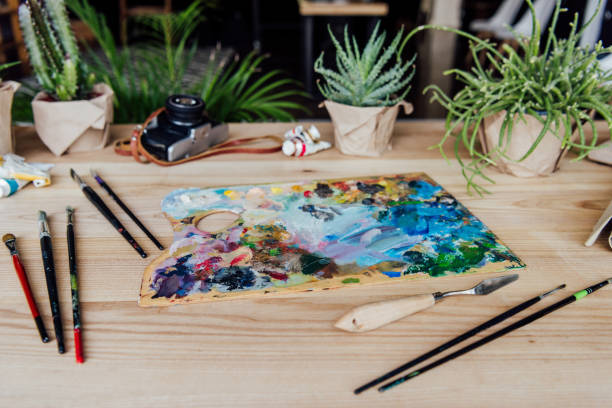 istock Creative workplace with art supplies, vintage camera and potted succulent plants 700788624