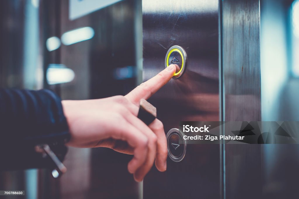 Mano empujando ascensor botón - Foto de stock de Ascensor libre de derechos