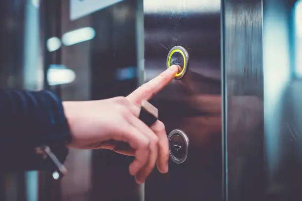 Photo of Hand pushing elevator button