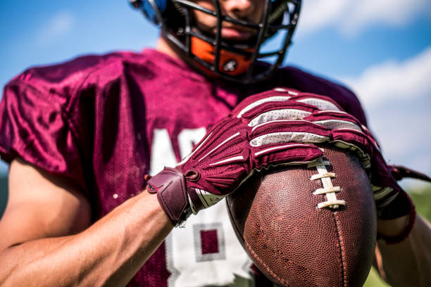 Cute little girl wearing a white and blue helmet for american football. She is looking away with a serious facial expression and she has black stripes on her chicks on face. Close up photo of her head shot in Ljubljana - Slovenia - Europe.