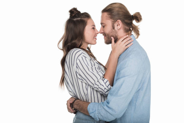 side view of happy young couple able to kiss isolated on white - couple indoors studio shot horizontal imagens e fotografias de stock