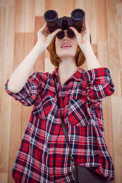 istock smiling hipster woman looking through binoculars 700797606