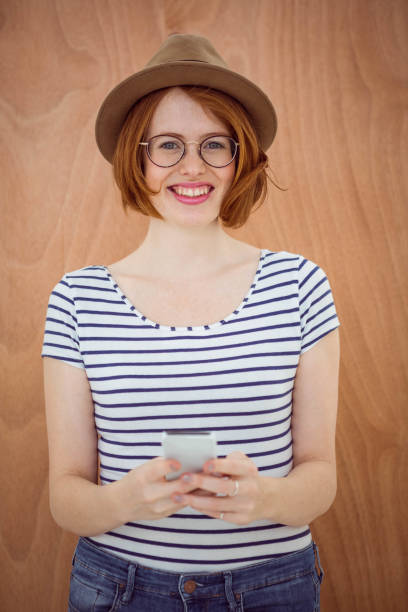 istock smiling hipster woman holding  a mobile phone 700799564