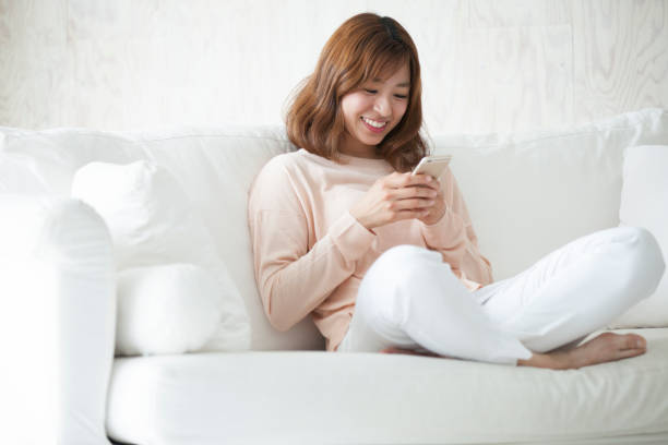 женщина, сидящая на диване - japanese ethnicity college student student asian ethnicity стоковые фото и изображения