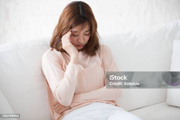 Woman Sitting On A Couch Stock Photo - Download Image Now - Women, Tired, Headache