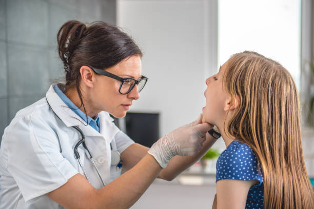 ärztin, die überprüfung des kleinen mädchens hals - child glasses eyewear little girls stock-fotos und bilder