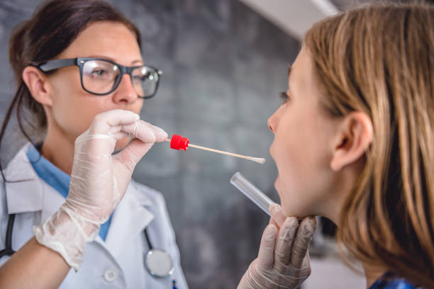 Female doctor taking a throat culture stock photo