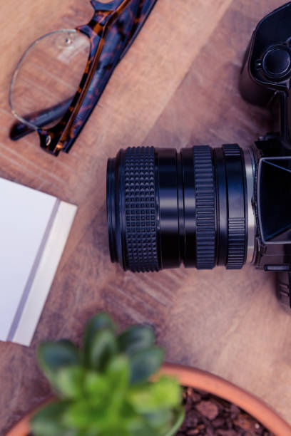 istock Camera by eye glasses on wooden table 700817258