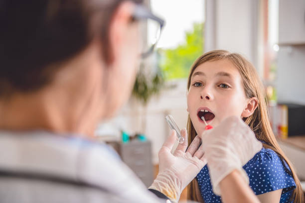 femme médecin prenant une culture de gorge - pharyngitis photos et images de collection