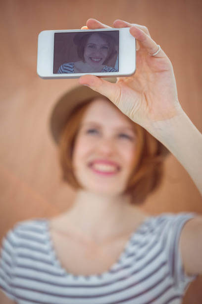 istock smiling hipster woman taking a selfie 700817896